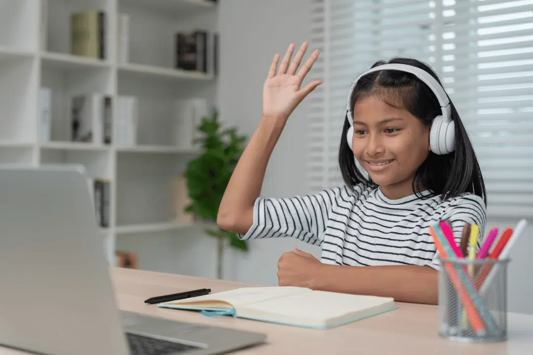 Engaged student interacting in online tutoring session with raised hand and focused attention
