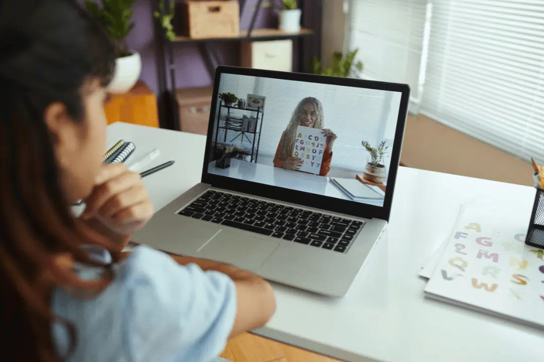 Online tutoring setup with student focused on interactive lesson displayed on laptop