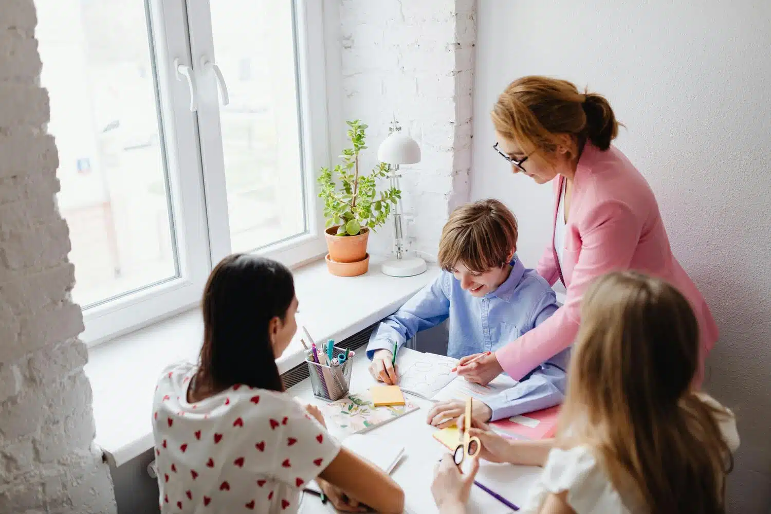 A female tutor guiding students through a lesson at a table